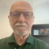 Harry Foxwell wears a green Mason polo shirt in his faculty profile for the IST department at George Mason University.