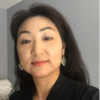 Jinyi Kim, IST PhD student at Mason, wears a black blazer and silver earrings in her profile.