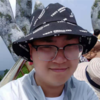 Xu He, IST PhD student at Mason, wears a light collared shirt and black hat in his profile.